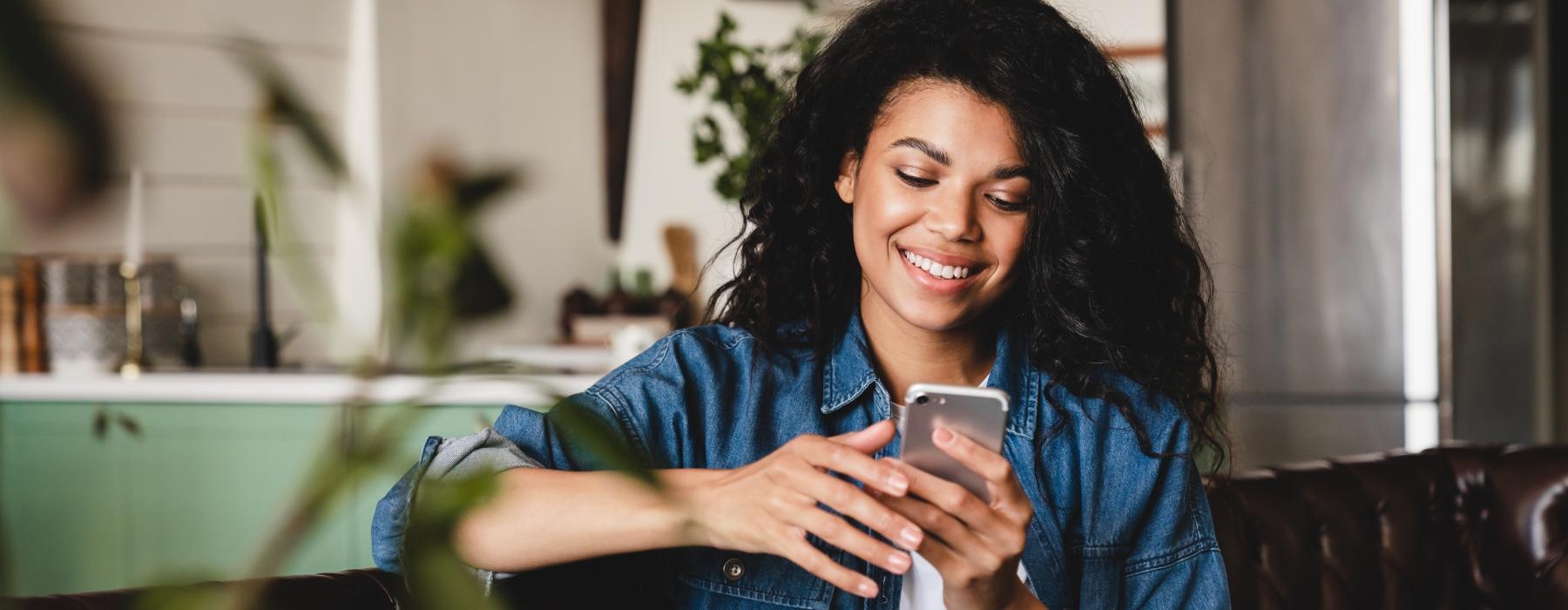 a person sitting on a couch and looking at the phone